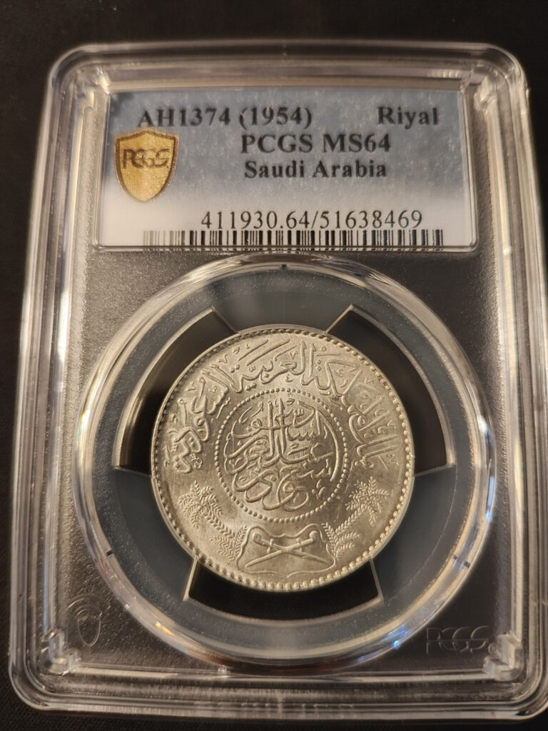 Read more about the article 1954 (AH 1374) Saudi Arabia 0.9+ Silver 1 Riyal – PCGS: MS 64