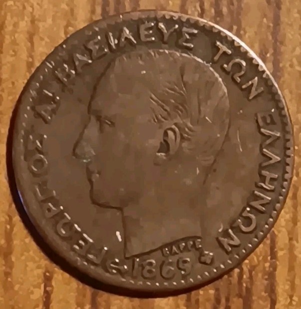 Read more about the article 1869 BB Greece Copper Lepton Coin  George I Ruler Young Head. VF+ Condition 0320